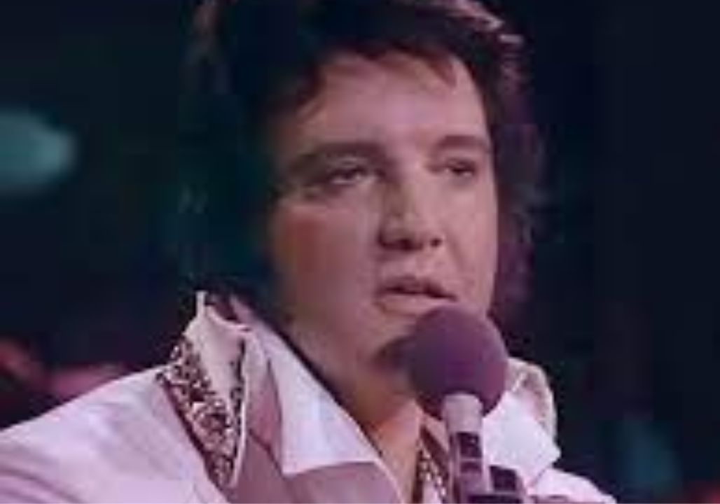 Elvis Presley—his body heavier, his face worn with fatigue—commanded silence the moment he began singing “Hurt.” This was not the young, electrifying Elvis of the past, but a man fighting the weight of his own decline. Yet when the melody swelled, he gave everything he had, stretching the high note until the hall itself seemed to tremble, before the crowd erupted in thunderous applause. With a weary smile and a hint of humor, Elvis said, “Thank you… I can’t do it any better,” only to surprise everyone by launching into the climax once more. In that instant, it was more than music—it was his soul pouring out. Tired but unyielding, he sang as if it were his last breath, a final testament that his life was bound to song. For many, it became one of Elvis’s most hauntingly unforgettable moments.