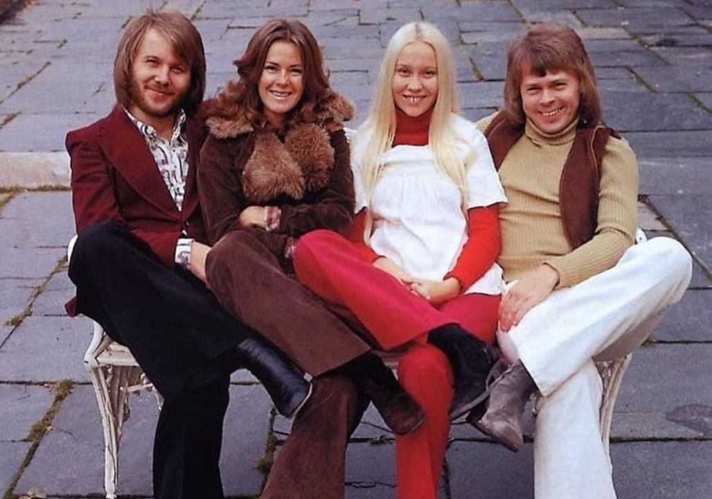 “ABBA STOPPED MID-SONG AND SAID, “WE KNOW OUR TIME IS RUNNING OUT…” The arena was singing with them—until the music suddenly softened, as if someone had turned down the world. Four silhouettes leaned toward the microphones, and for a heartbeat the crowd didn’t cheer. They listened. Then came the words that hit harder than any chorus: ABBA STOPPED MID-SONG AND SAID, “WE KNOW OUR TIME IS RUNNING OUT…” In the rows of faces, smiles wavered into tears. People clutched hands, remembering weddings, first dances, long drives, and loved ones no longer here. The song resumed—but nothing sounded the same. It wasn’t just a performance anymore. It was a farewell in slow motion.”””